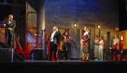 The Majordomo (actor Will LeBow) informs the Music Master (baritone Jake Gardner), Wigmaker (baritone Anton Belov), Tenor (tenor Brandon Jovanovich), Nymphs (mezzo-soprano Andrea Coleman, soprano Mara Bonde, soprano Joanna Mongiardo), Composer (seated - mezzo-soprano Edyta Kulczak) and Lackey (bass John Whittelsey) that there will be a dramatic change to the evening’s performance schedule., Ariadne auf Naxos, Boston Lyric Opera, 2010