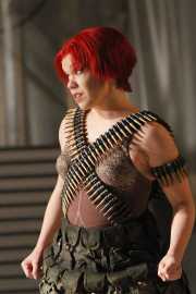 Soldier Girl (Kathryn Skemp, soprano) contemplates life before the war. Sandra Kott, principal violin and Concert Mistress for the chamber orchestra, led by conductor Steven Lipsitt, is in the background. In a break from traditional performance, the chamber orchestra performs onstage throughout the opera, 2011
