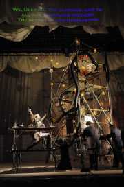 A wide shot of the scenery of BLO’s new production of The Emperor of Atlantis, or Death Quits, which was inspired by original sketches made by librettist Petr Kien in Terezín. Bass Kevin Burdette as Loudspeaker watches as the “palace” of Emperor Überall (Andrew Wilkowske, baritone) is moved by his soldiers. The Emperor’s proclamation to the world is projected above the stage, 2011