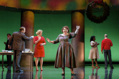 Amidst all the drama and intrigue at the State Department Christmas party, Miss Lightfoot (Michelle Trainor, center) encourages the crowd to have fun in Boston Lyric Opera’s production of “Fellow Travelers,” playing Nov. 13-17 at the Emerson Paramount Center.