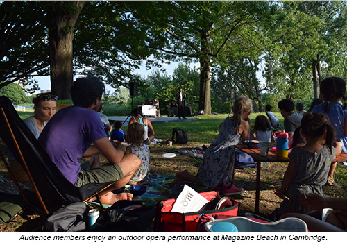 Audience members enjoy an outdoor opera performance at Magazine Beach in Cambridge.